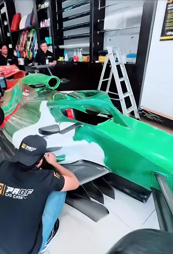 فني PROF Car Care يطبّق الفيلم على هيكل سيارة الفورمولا